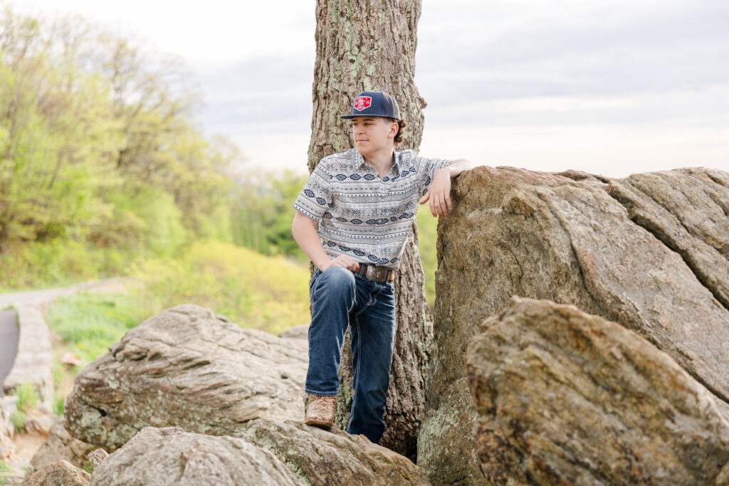 Senior posing on a rock on Skyline Drive overlook in Shenandoah National Park