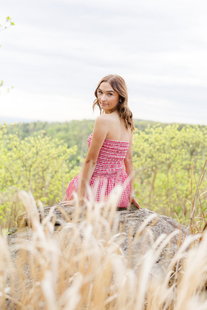 High school senior girl posing at sunrise with mountain views in Shenandoah National Park